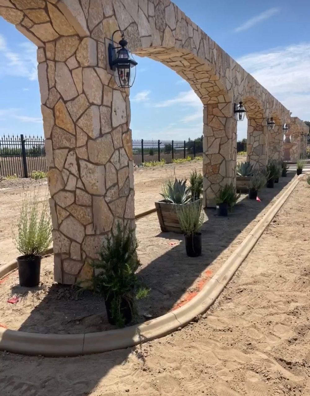 A stone archway with potted plants underneath it
