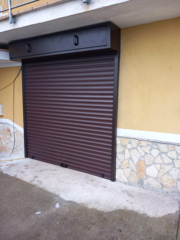 Serranda di sicurezza marrone su un edificio giallo.