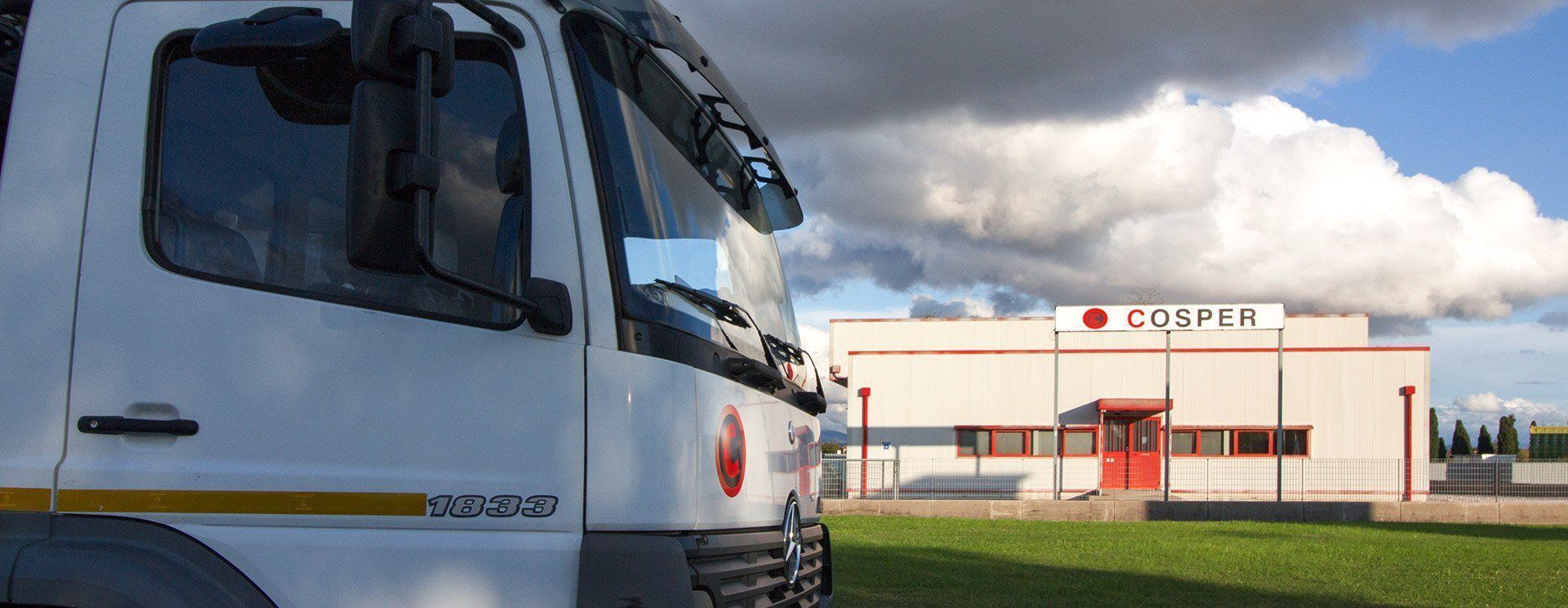 Un camion bianco è parcheggiato davanti a un edificio su cui c'è scritto