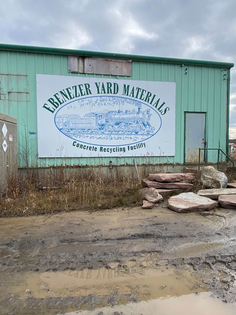 A green building with a large white sign on the side of it.