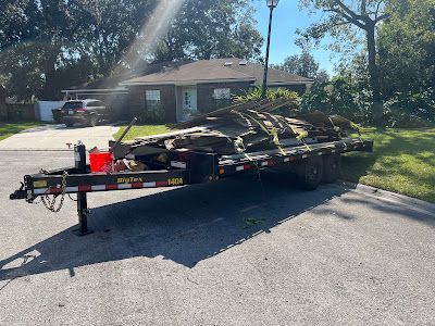 A trailer is parked on the side of the road in front of a house.