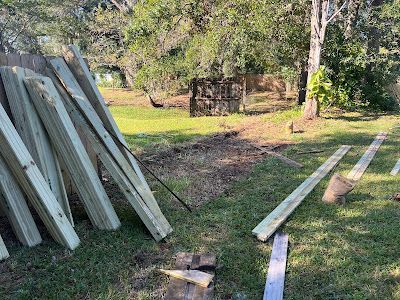 A pile of wood sitting on top of a lush green field.