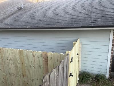 A wooden fence is sitting in front of a house.