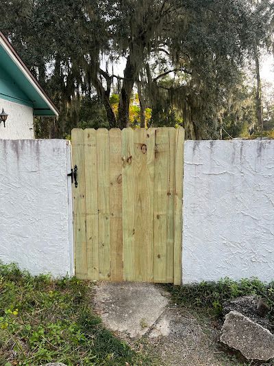 A wooden gate is sitting in front of a white wall.