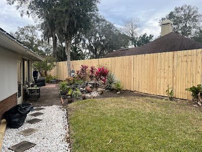 There is a wooden fence in the backyard of a house.