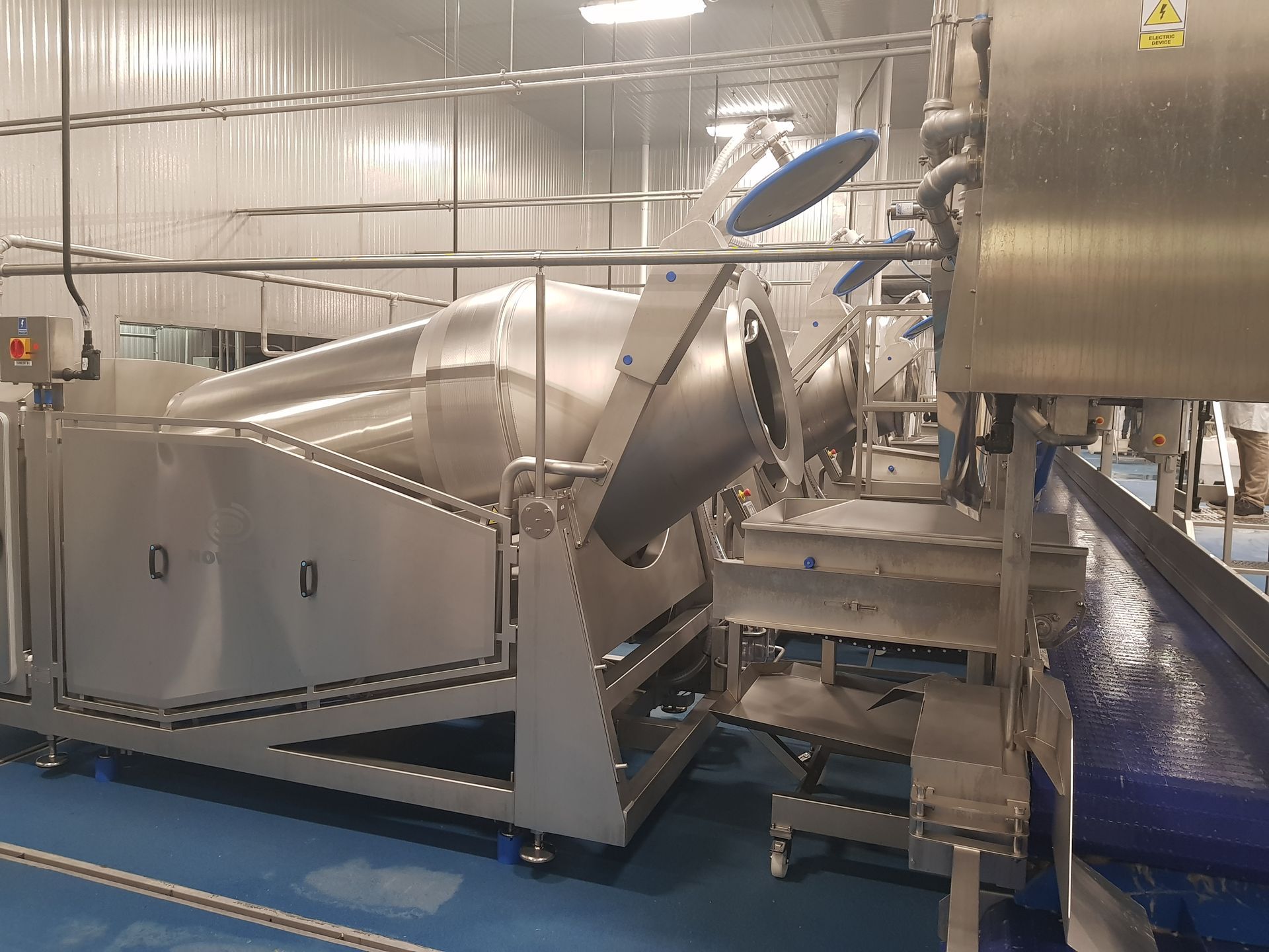 A large stainless steel machine is sitting in a factory.