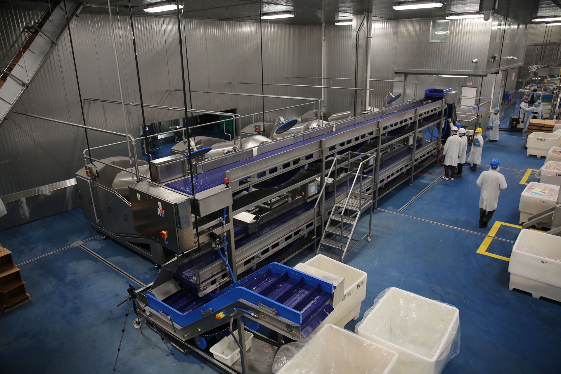 A factory filled with lots of boxes and a conveyor belt.