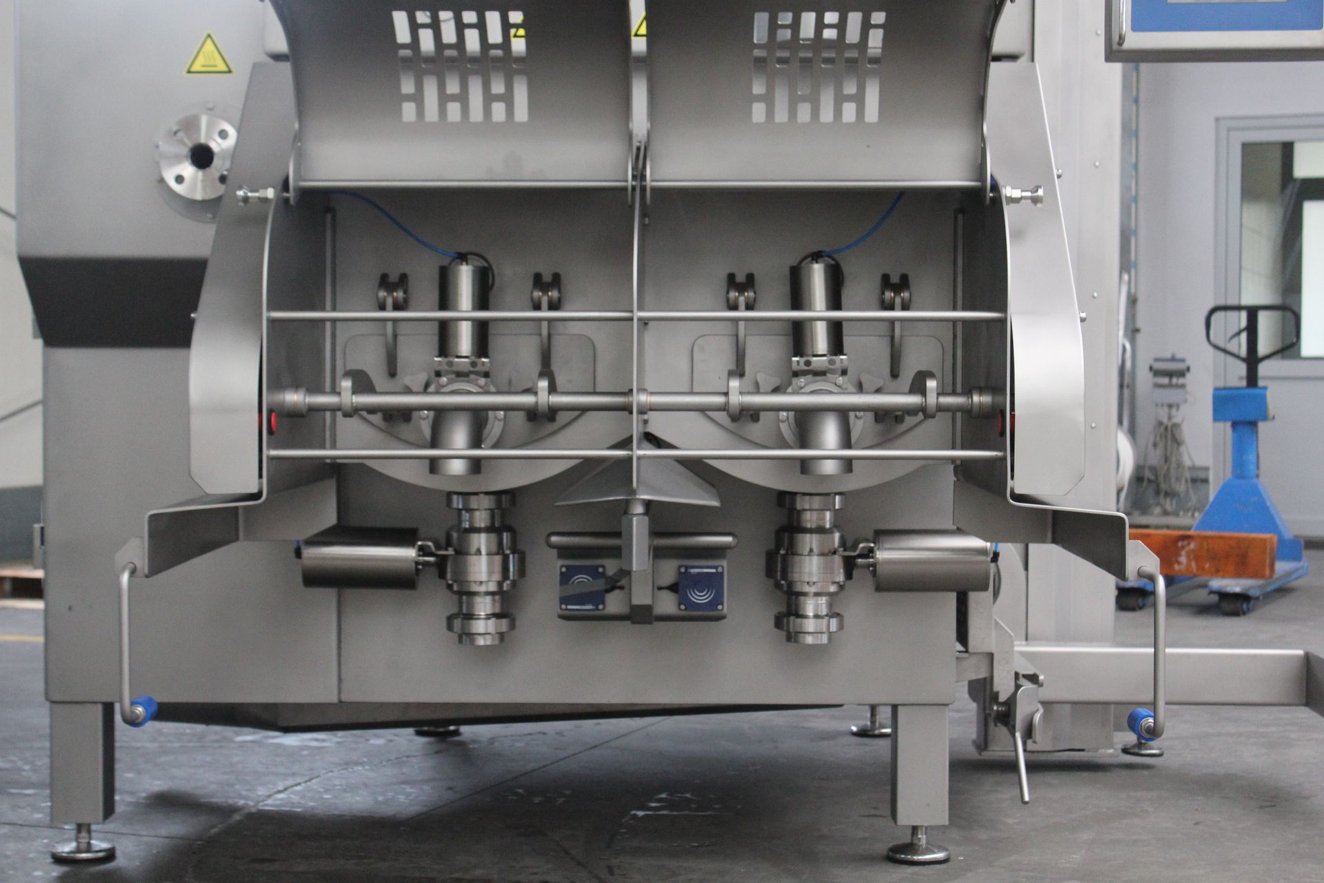 A large stainless steel machine is sitting on the floor in a room.