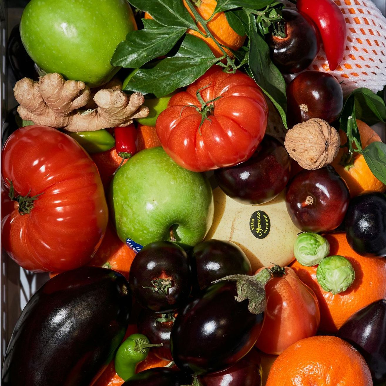 A variety of fruits and vegetables including tomatoes and apples