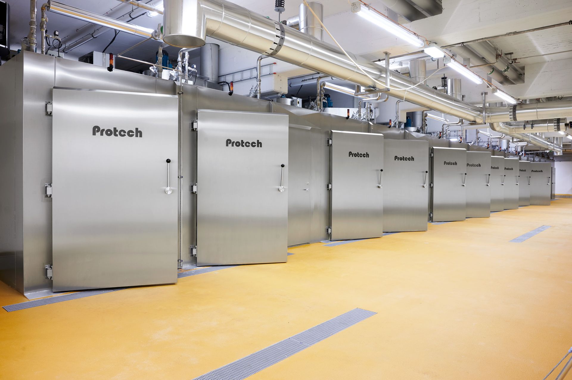 A row of stainless steel doors are lined up in a room.