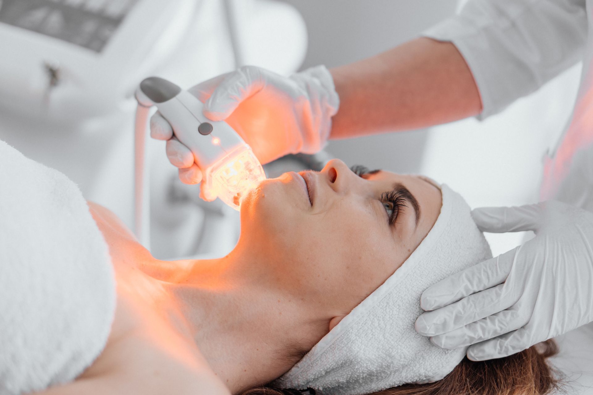 una donna sta ricevendo un trattamento cosmetico sul viso in un salone di bellezza .