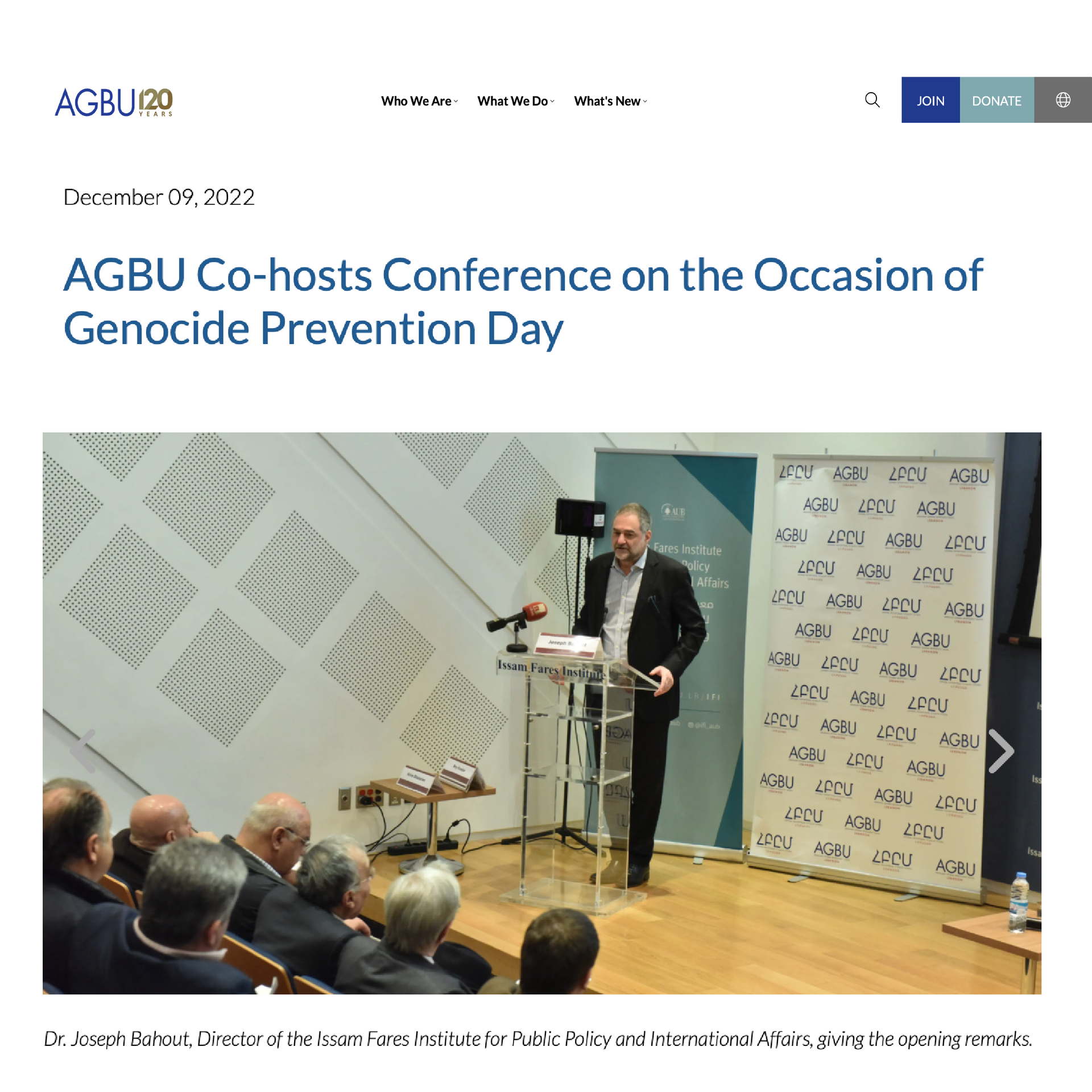 AGBU press feature showing man speaking at a podium with AGBU banner behind her relates to a genocide prevention conference