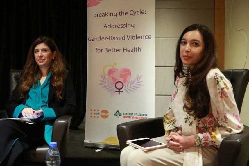 Lynn Zovighian In a UNFPA & MOPH policy session. Banner behind her reads Addressing gender-based violence for better health.