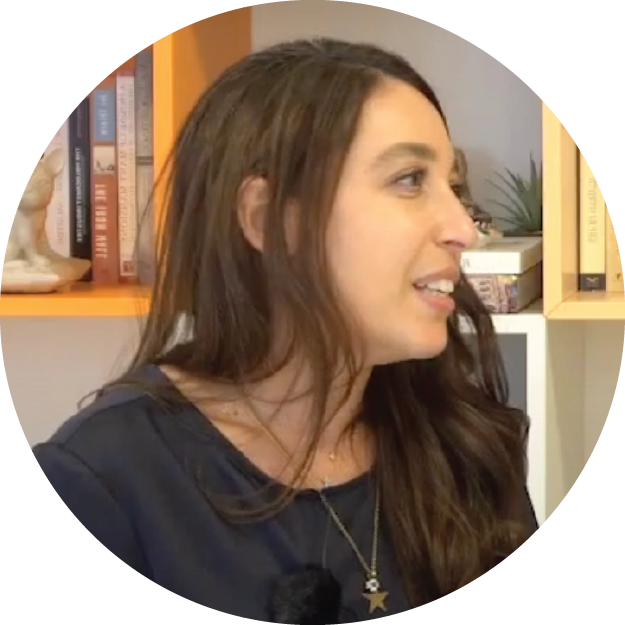 Lynn Zovighian portrait image looking to the right, sitting in front of a book shelf