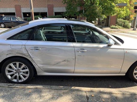 A person is taking a picture of a car with a cell phone