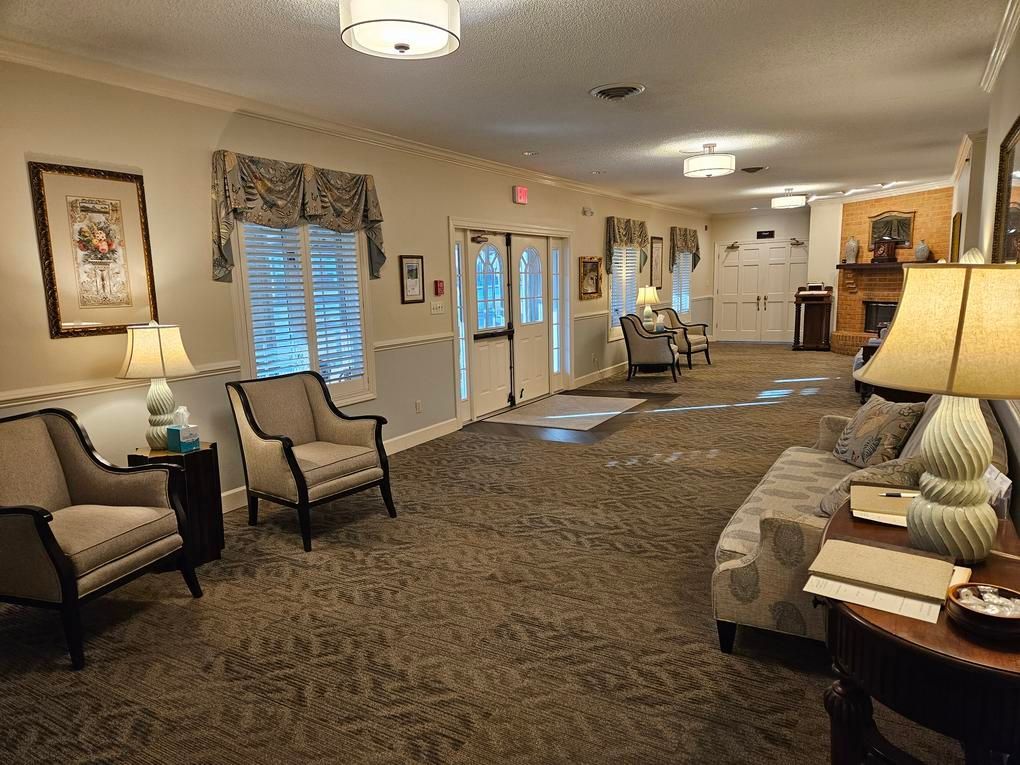 A brightly lit waiting room with seating, artwork, and a fireplace.