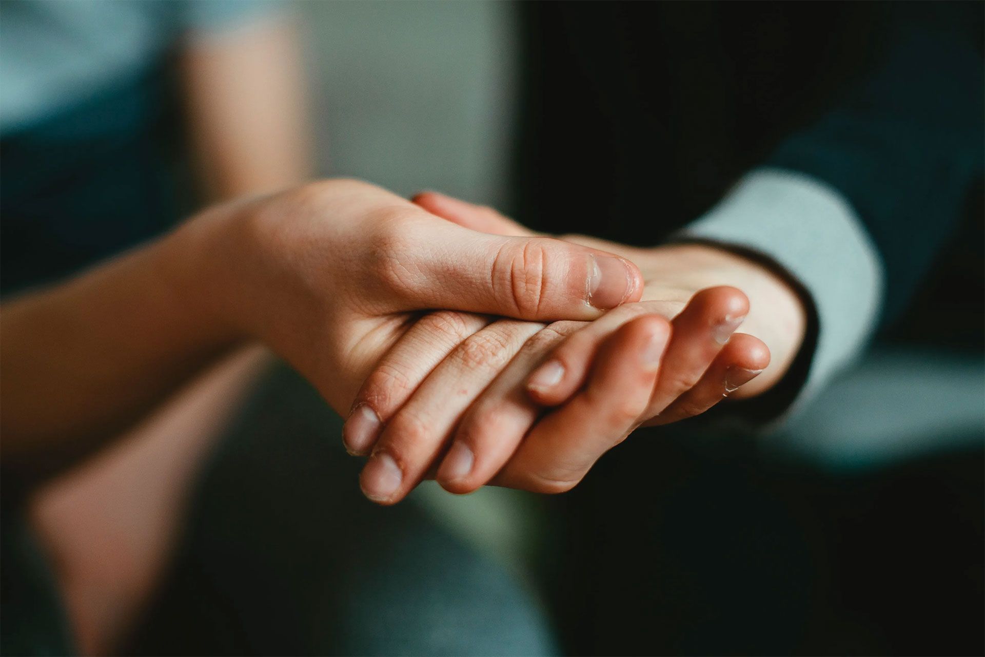 Hands clasped together, offering comfort and support.