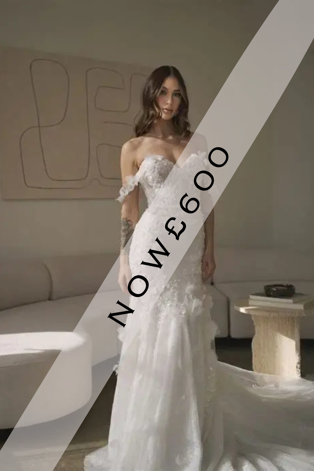 Lady stood in Ivory, lace, fishtail wedding dress. The wedding dress has soft 3D floral lace off the shoulder straps, 3D floral lace on the bodice that drops down onto the top of the skirt.