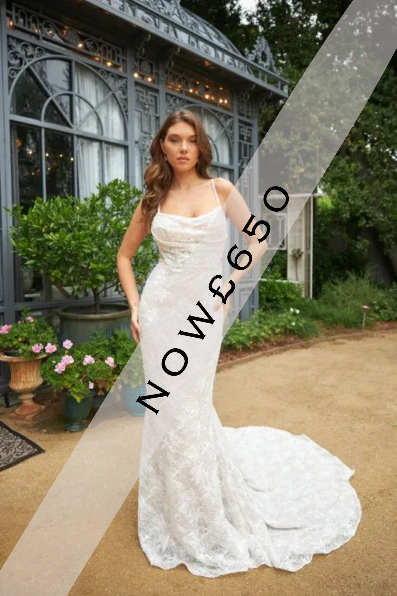 Lady stood in a delicate soft lace and beaded Ivory wedding dress by Martina Liana. It is a fitted wedding dress with delicately beaded thin straps.