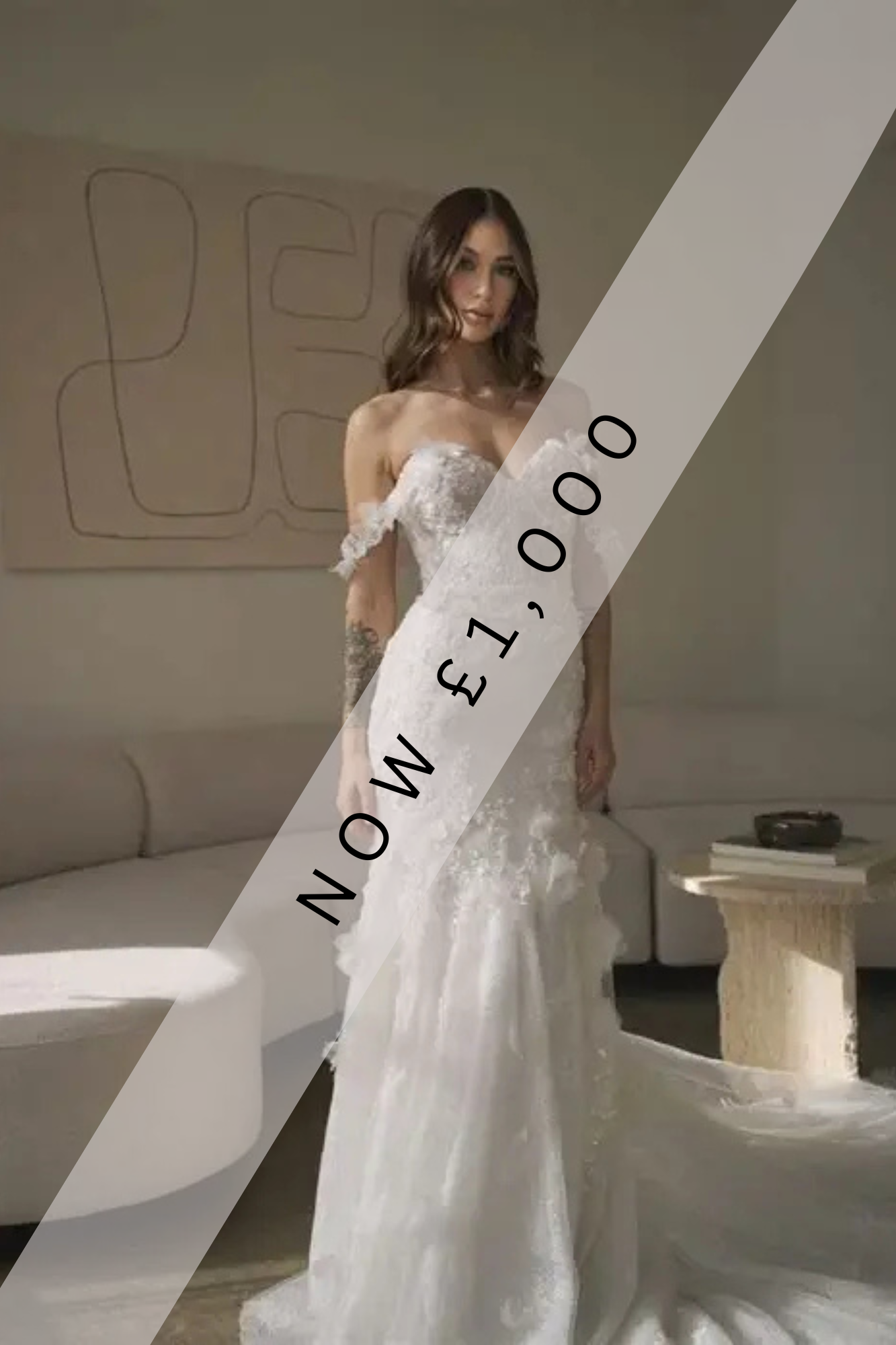 Lady stood in Ivory, lace, fishtail wedding dress. The wedding dress has soft 3D floral lace off the shoulder straps, 3D floral lace on the bodice that drops down onto the top of the skirt. 