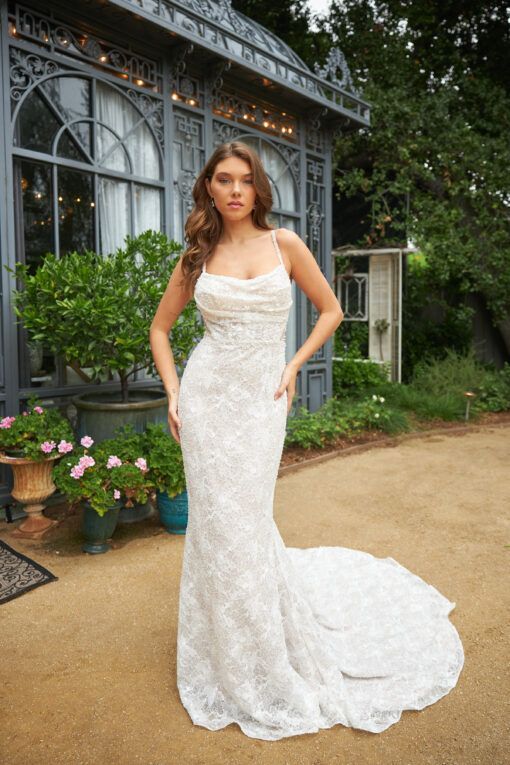 Lady stood in a delicate soft lace and beaded Ivory wedding dress by Martina Liana. It is a fitted wedding dress with delicately beaded thin straps.