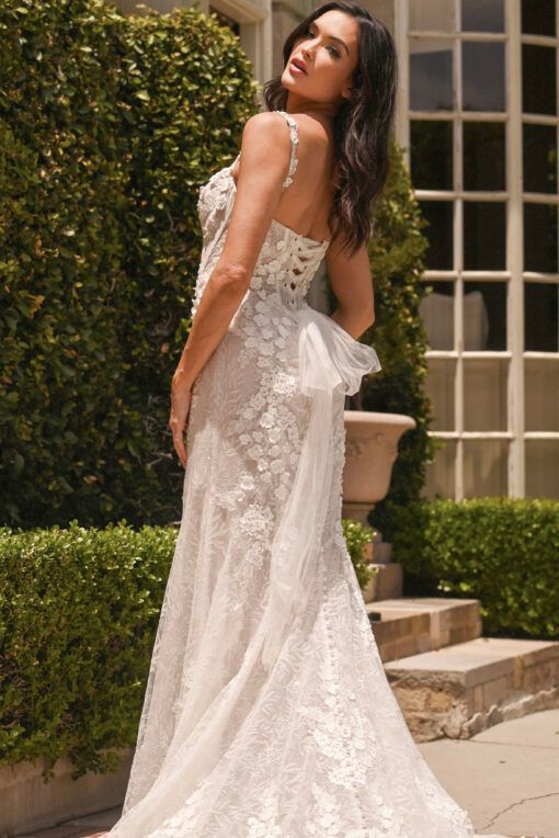 Lady stood in lace detailed, Ivory wedding dress by Martina Liana. The wedding dress has lace motif going down the back, corset back and buttons all down the back of the wedding dress.