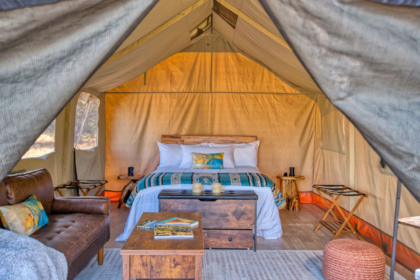 A bed in a tent with a view of the desert