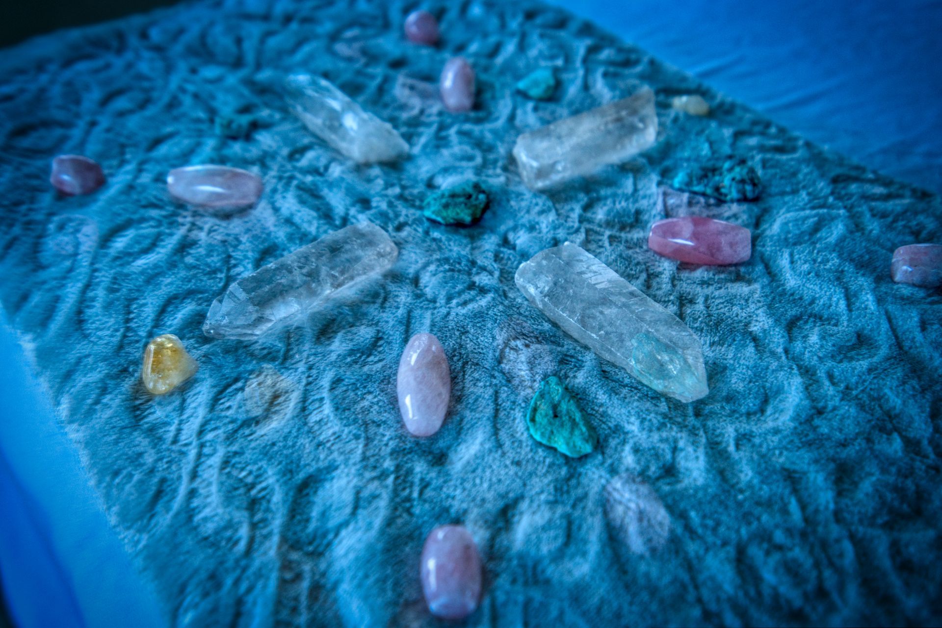 A candle , crystals , and dried flowers are on a table.