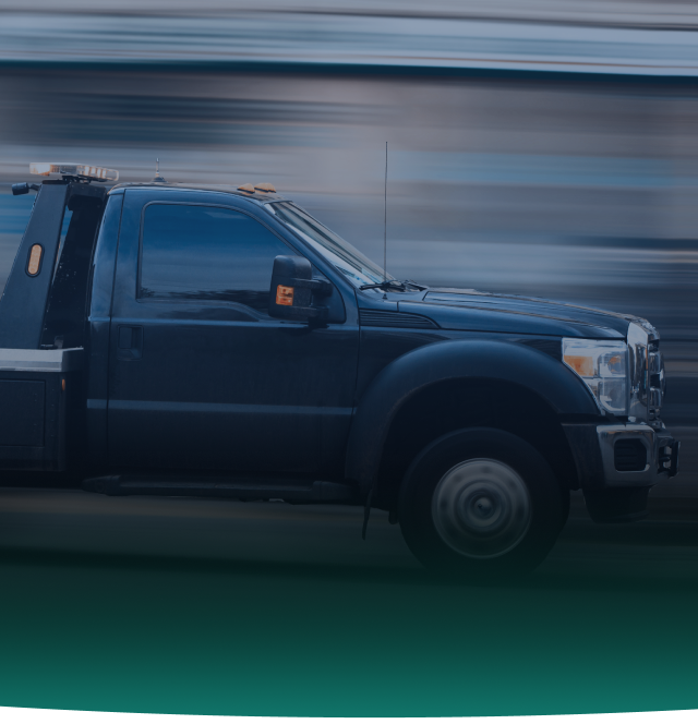 Dark tow truck in motion with blurred background. | Chicago Cheap Tows