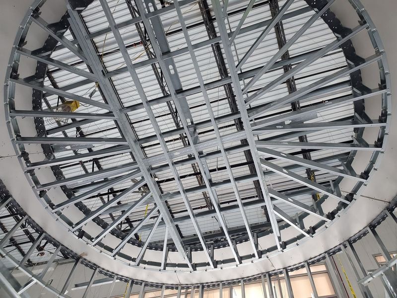 The ceiling of a building is being built and looks like a dome.