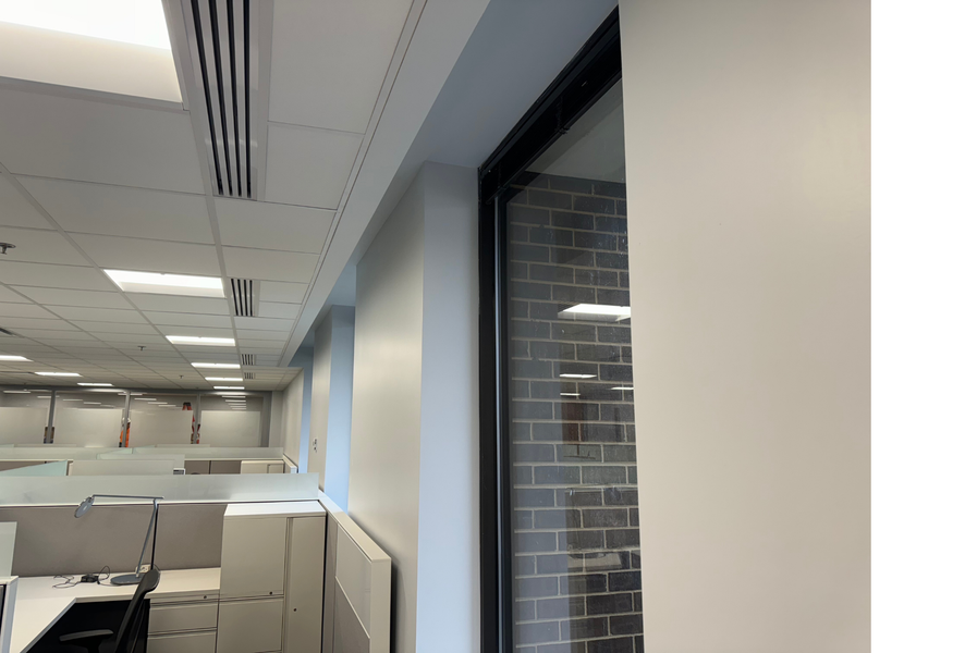 An office with cubicles and a brick wall