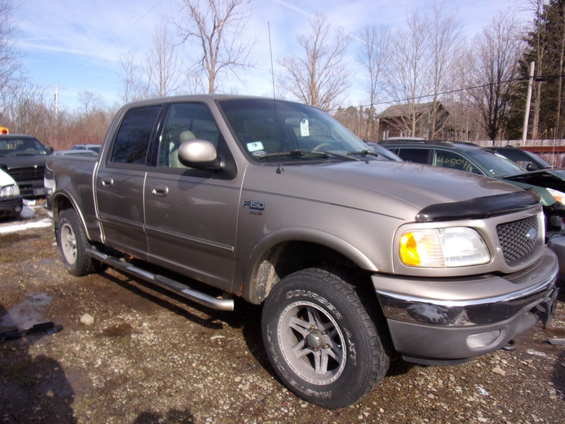 a ford f150 truck is parked in a gravel lot