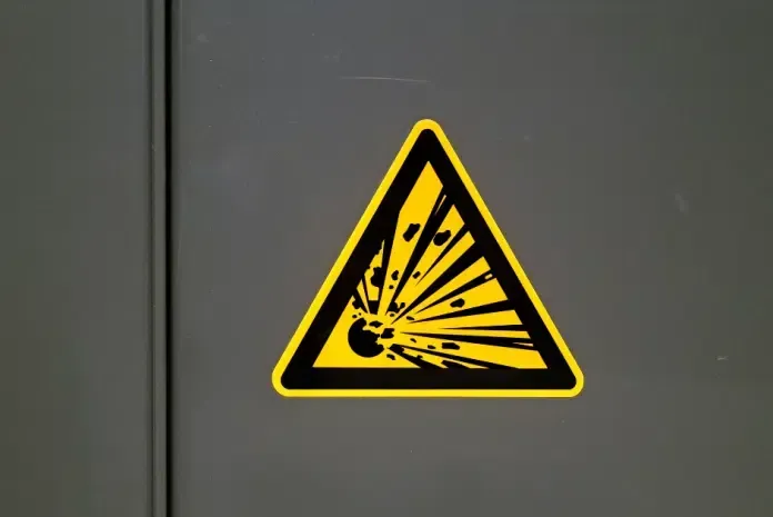 Un segnale di avvertimento giallo con un bordo triangolare nero e un'icona nera raffigurante un'esplosione.