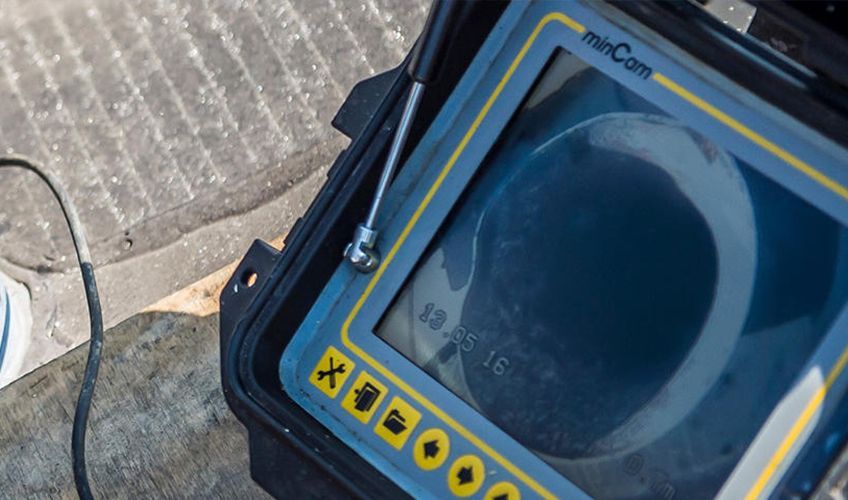 Primo piano dello schermo di una telecamera per l'ispezione di tubi minCam, che mostra una vista circolare dell'interno di un tubo.