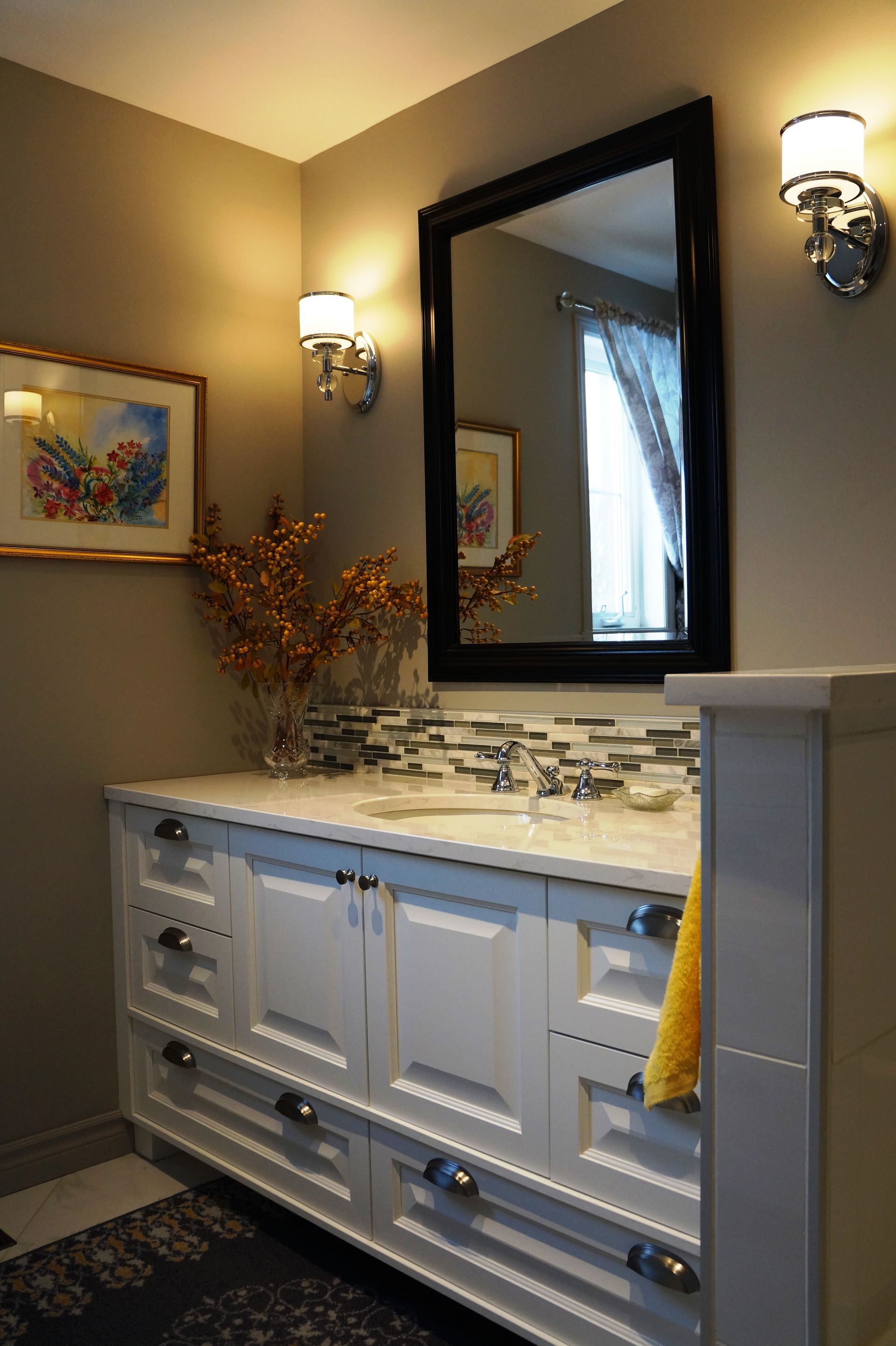 Une salle de bain avec un lavabo, un miroir et des armoires.