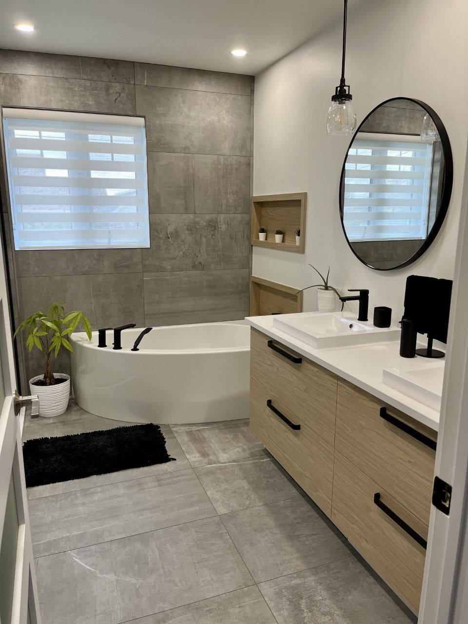 Une salle de bain avec deux lavabos, une baignoire et un miroir.