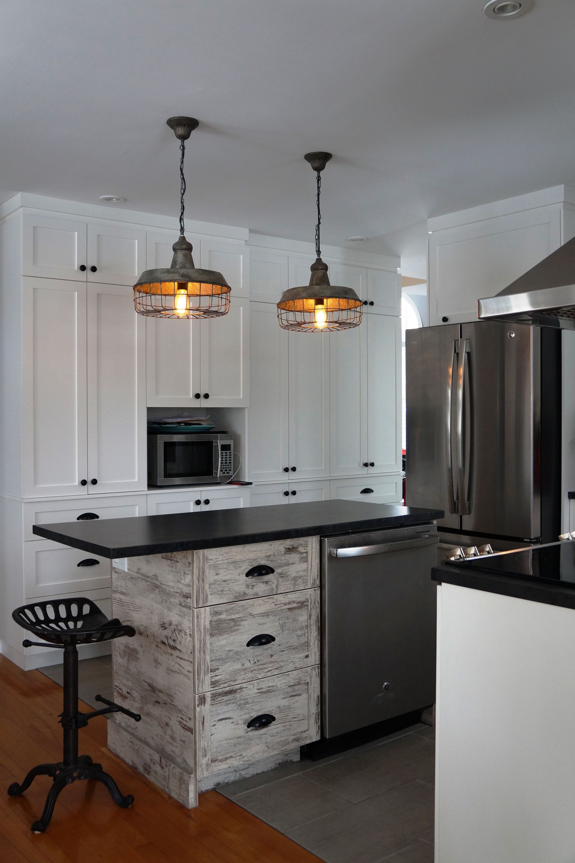 Une cuisine avec des armoires blanches et un comptoir noir