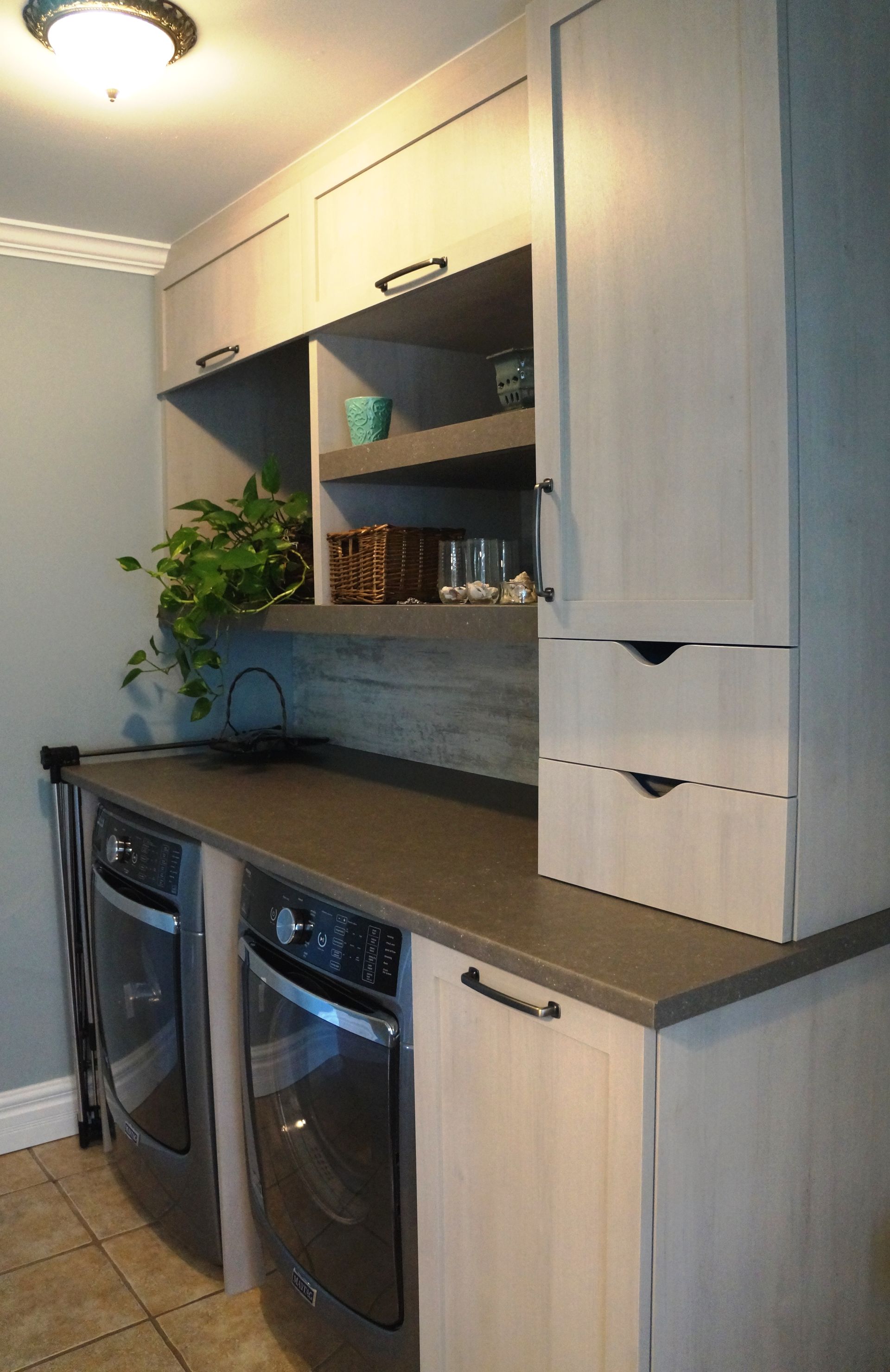 Une buanderie avec laveuse et sécheuse et un évier.