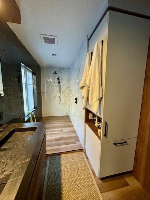Une salle de bain avec une douche à l'italienne et un lavabo