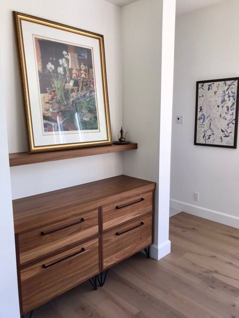 Une image sur une étagère au-dessus d'une commode en bois