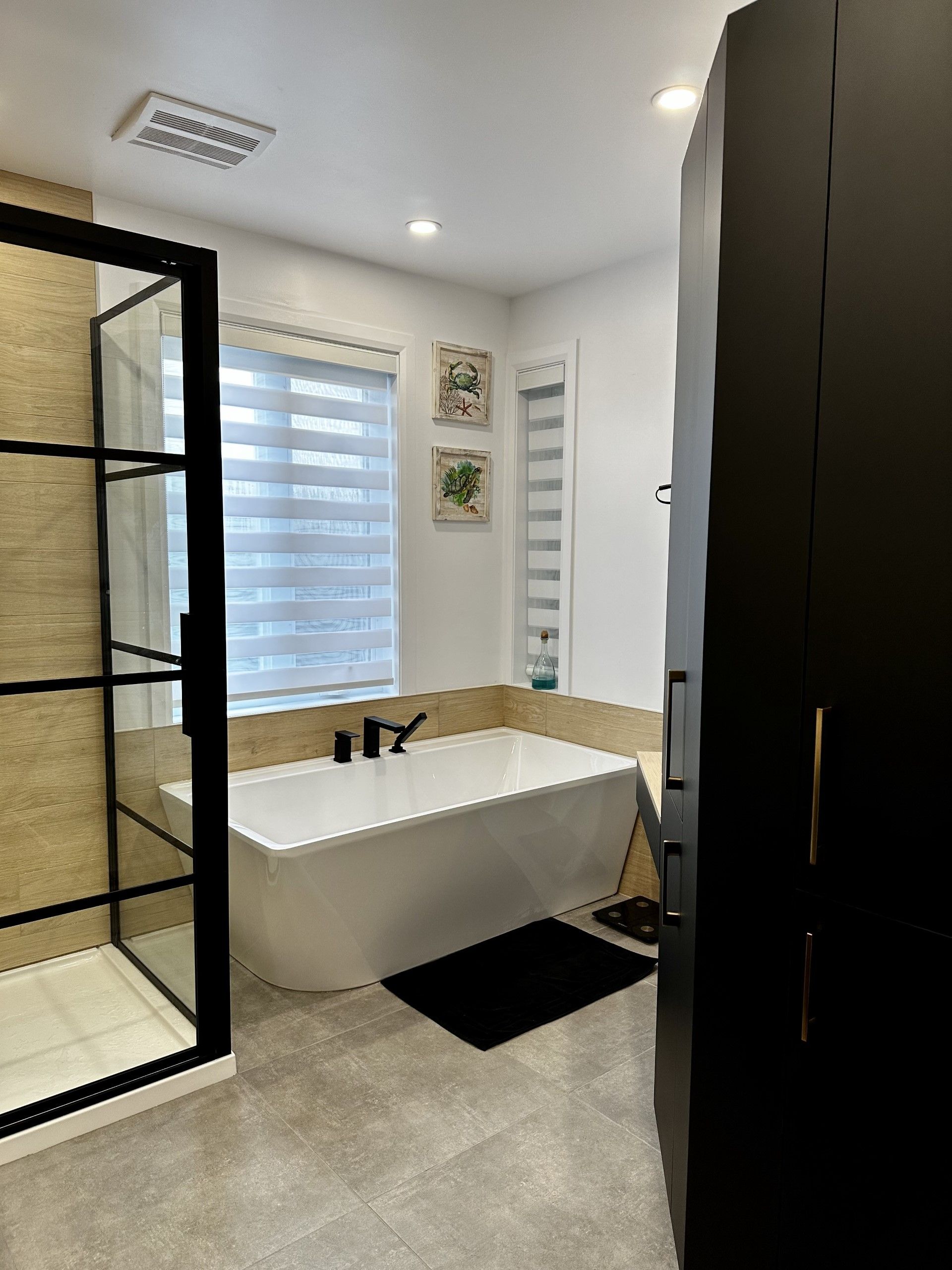 Une salle de bain avec baignoire, douche et fenêtre.