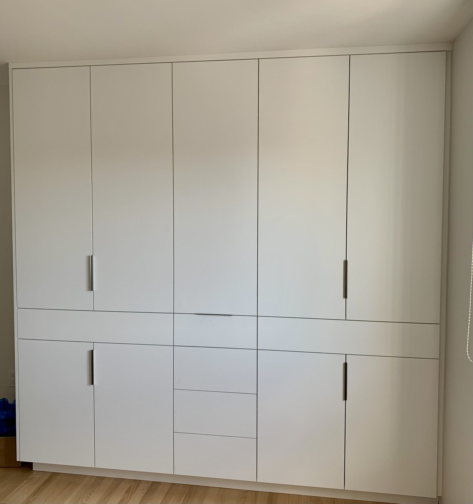 Une grande armoire blanche avec beaucoup de tiroirs et de portes