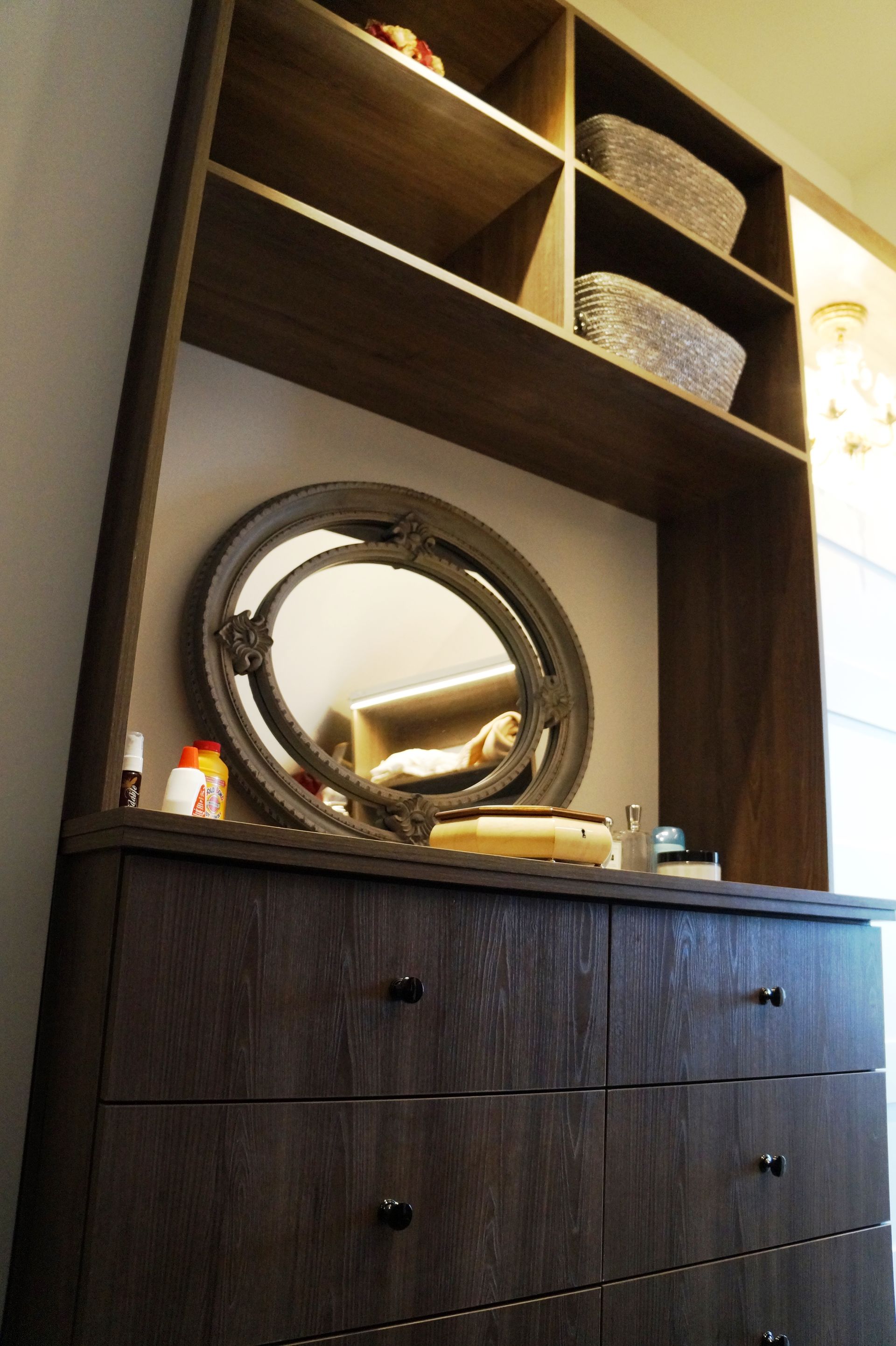 Une commode avec un miroir rond dessus