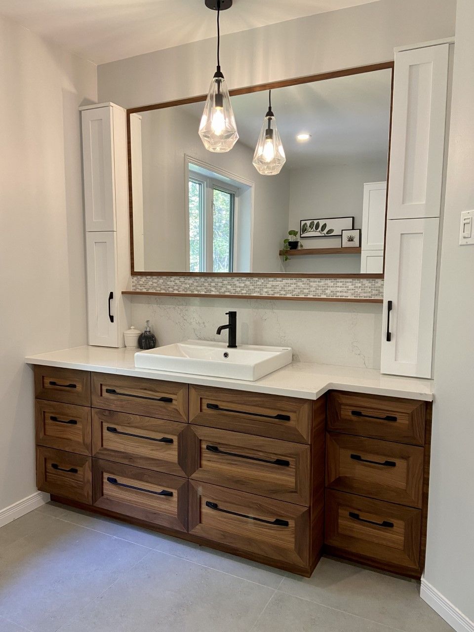 Une salle de bain avec deux lavabos et un grand miroir.