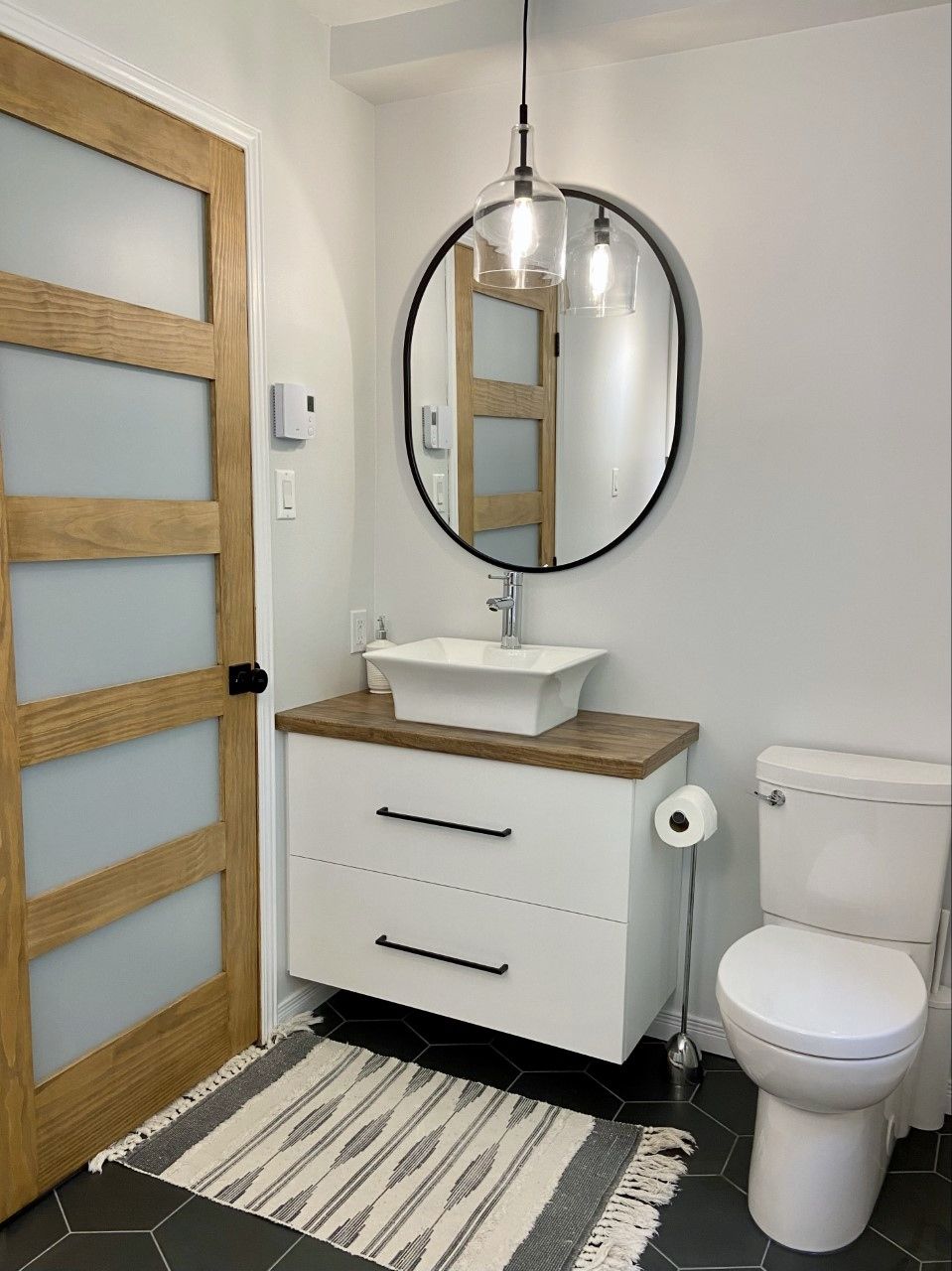 Une salle de bain avec un lavabo, des toilettes et un miroir.