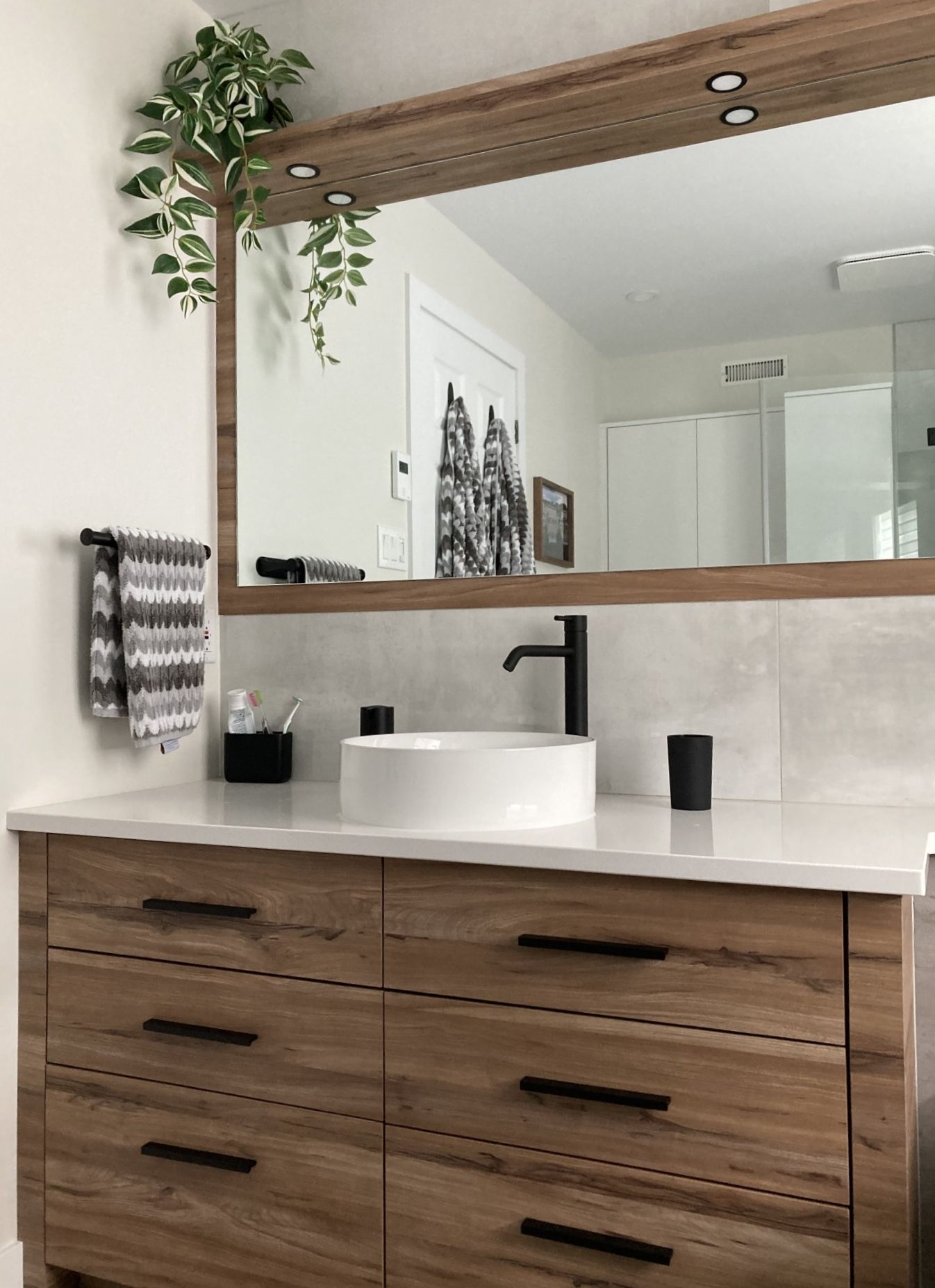 Une salle de bain avec un lavabo, un miroir et une commode.