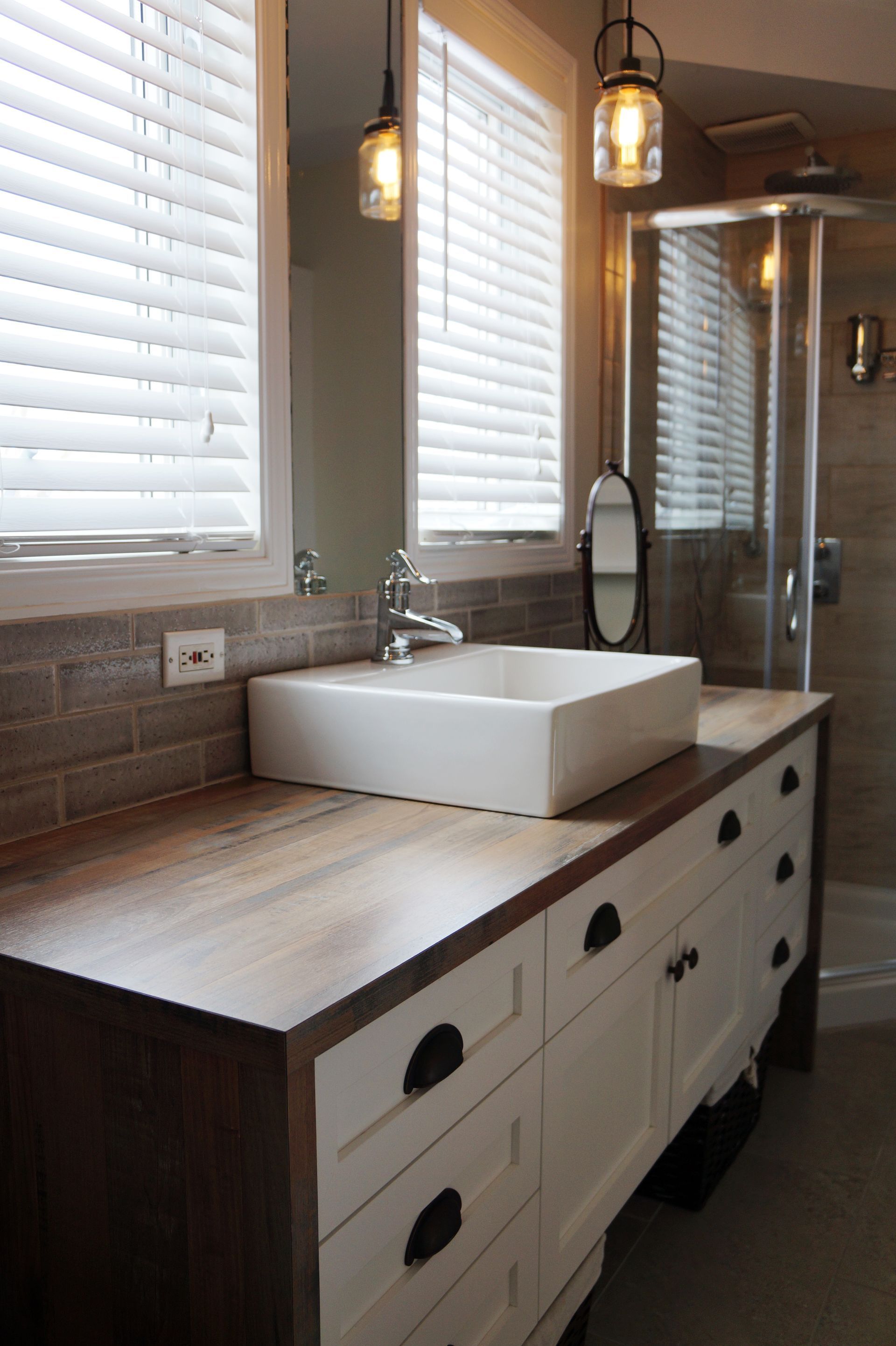 Une salle de bain avec lavabo, miroir et douche.