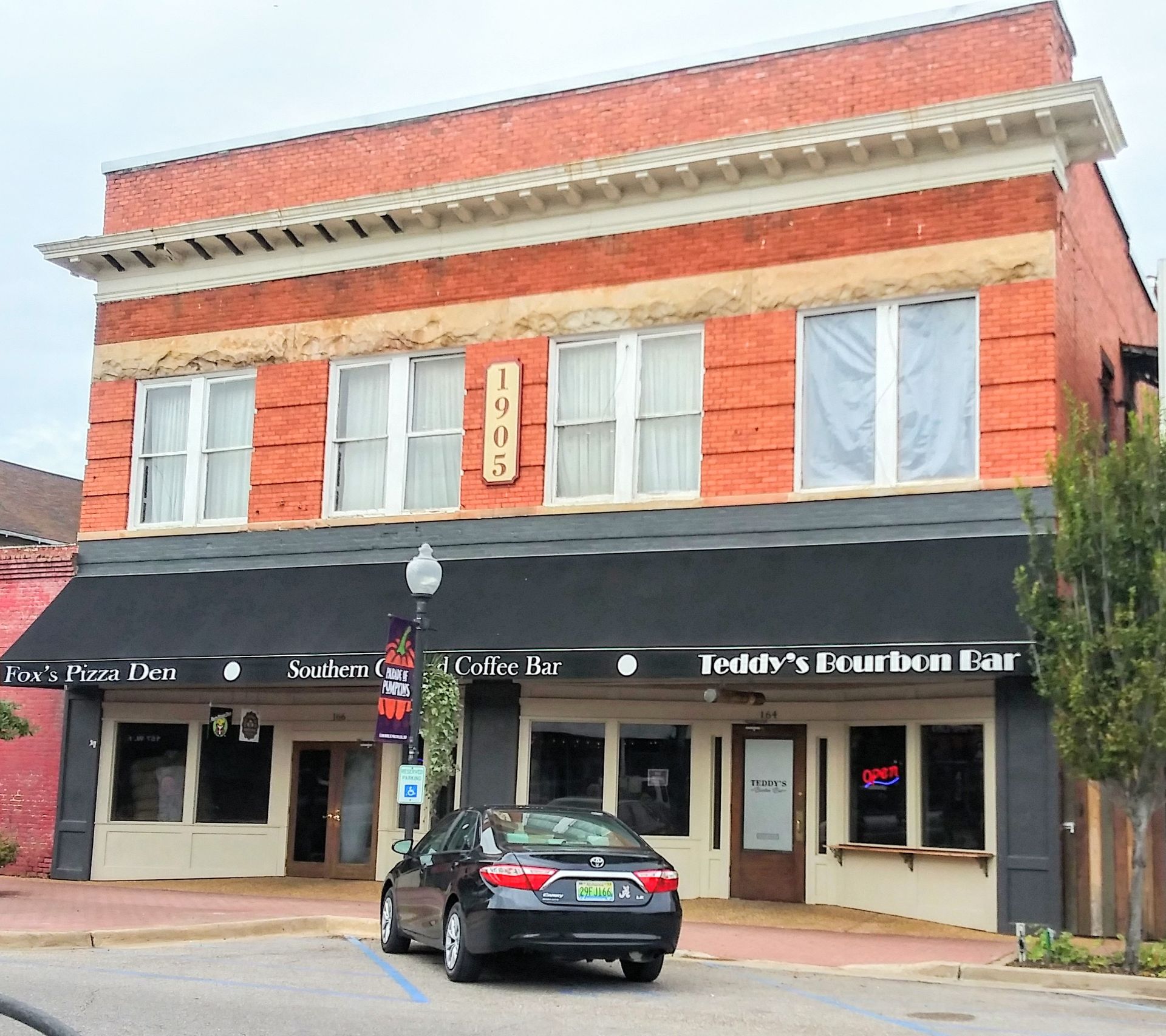 A car is parked in front of a building that says teddy 's traditional bar