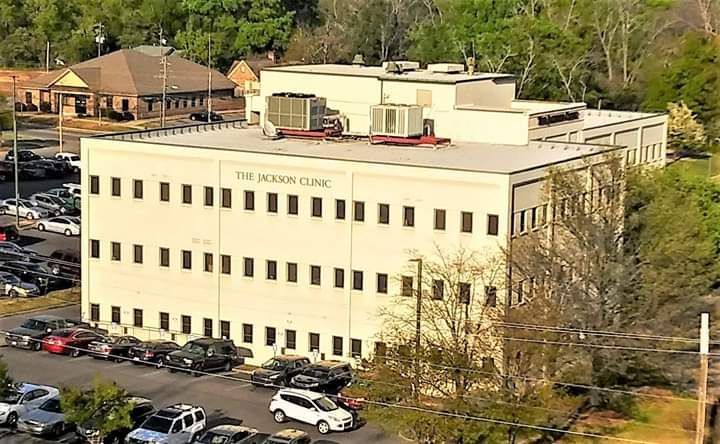 A large white building with a lot of cars parked in front of it.