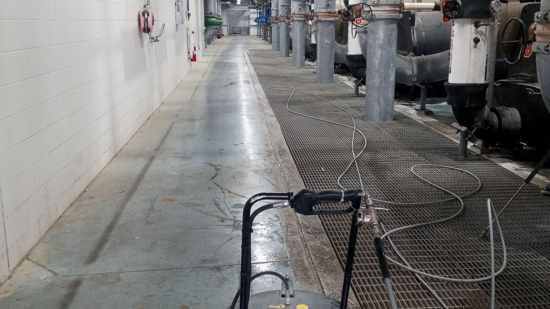 A walker is sitting in the middle of a hallway in a factory.